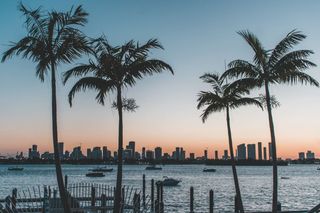 Miami financial district skyline at dusk seen across Biscayne Bay.