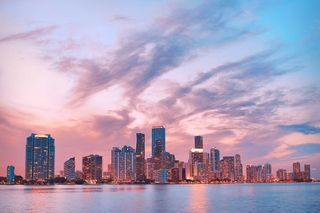 Miami skyline of glass high-rise towers seen at dusk.